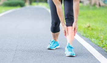 Illustration showing the anatomy of shin splints, highlighting the tibia (shinbone) and surrounding muscles, with areas commonly experiencing pain due to overuse or stress, often relieved by custom orthotics.